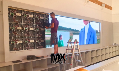 tecnici MX LEDWALL durante l'installazione di un led wall retro cassa nel Retail Dal Ben Abbigliamento