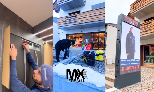 tecnici MX LEDWALL durante l'installazione di un totem bifacciale led e schermo per interno negozio a Andalo da Bottamedi Sport